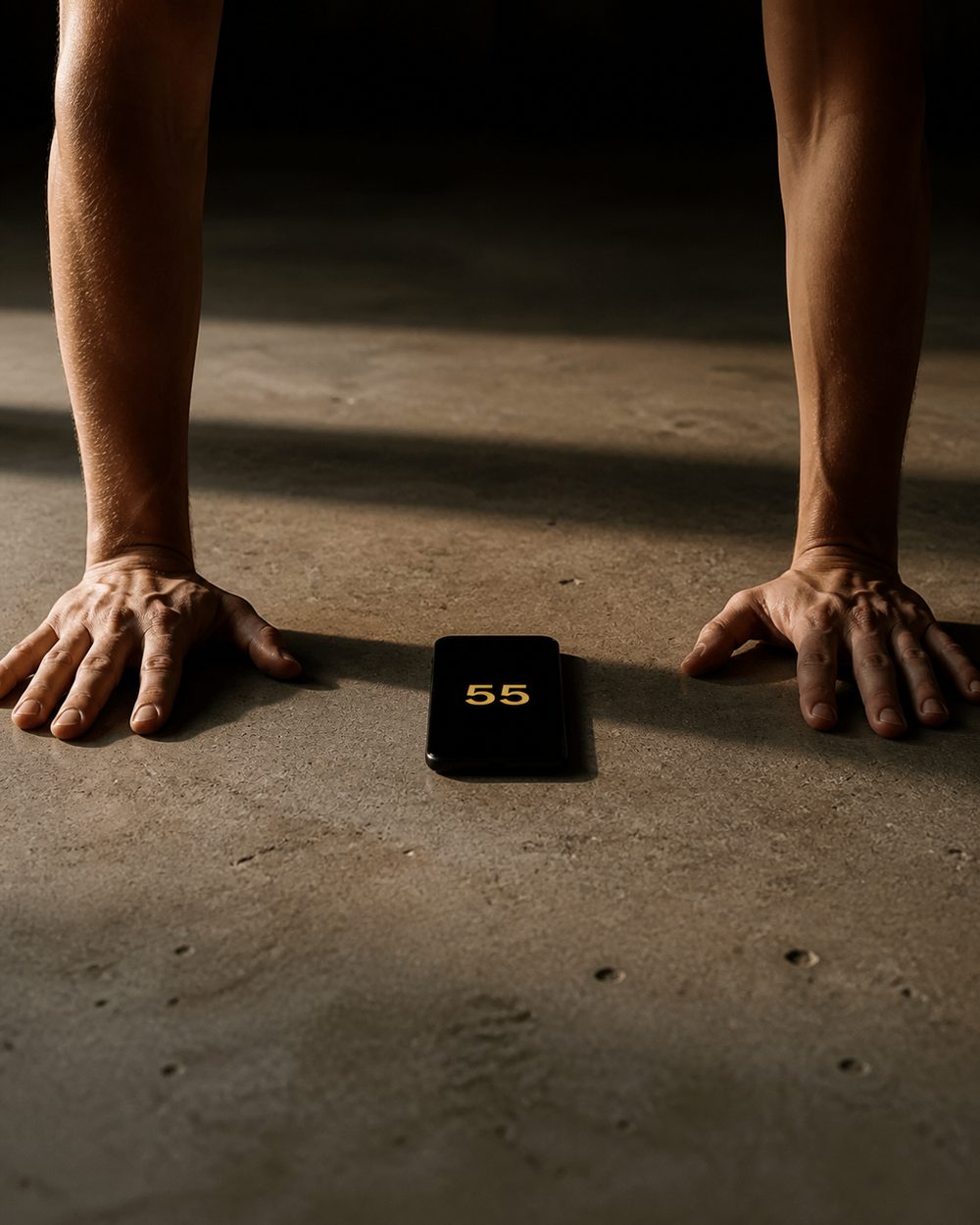 Hands planted on concrete at the top of a push-up